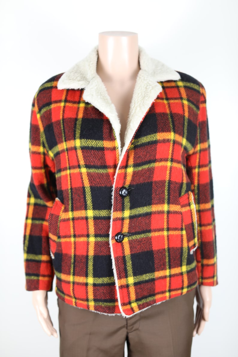 May include: A red, black and yellow plaid jacket with a white faux fur collar. The jacket has a button closure and two pockets.
