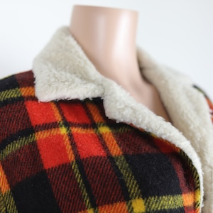 May include: A red, black, yellow and green plaid jacket with a white faux fur collar.