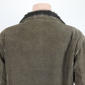 May include: A brown corduroy jacket with a black faux fur collar.