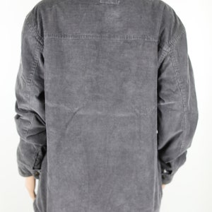 May include: A gray corduroy jacket with a sherpa collar. The jacket has a button closure and two pockets on the front.