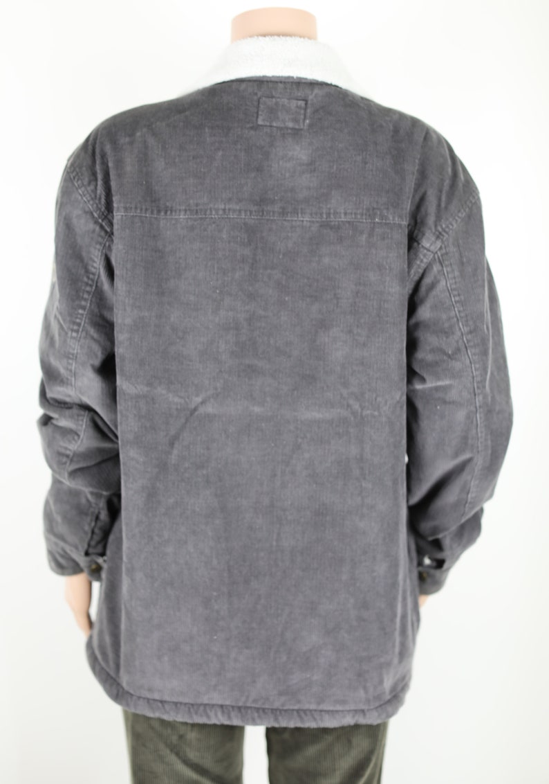 May include: A gray corduroy jacket with a sherpa collar. The jacket has a button closure and two pockets on the front.