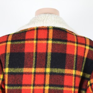 May include: Red, black and yellow plaid jacket with a white faux fur collar.