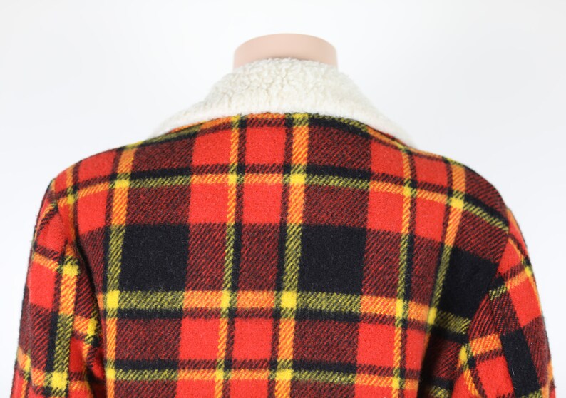 May include: Red, black and yellow plaid jacket with a white faux fur collar.