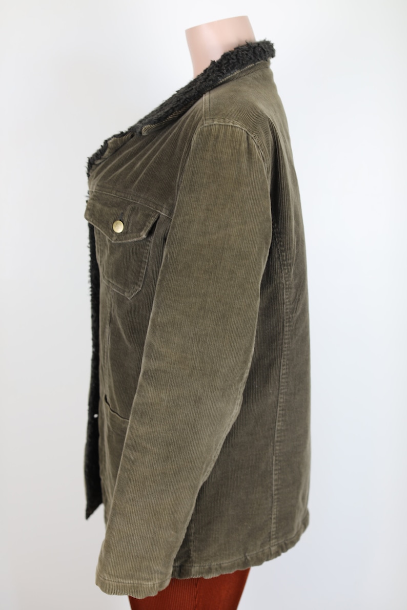 May include: A brown corduroy jacket with a black faux fur collar. The jacket has a button closure and two pockets.