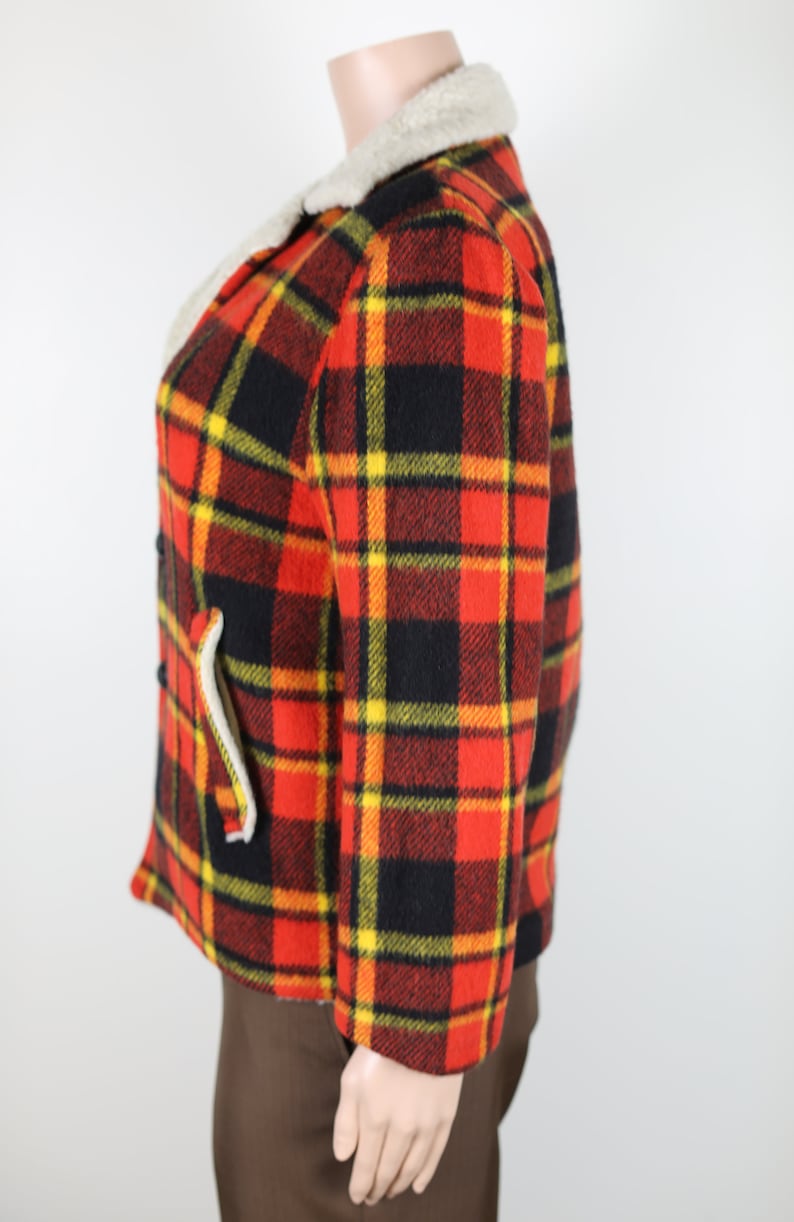 May include: A red, black and yellow plaid jacket with a faux fur collar. The jacket is made of a thick, warm fabric and has a classic, vintage style.
