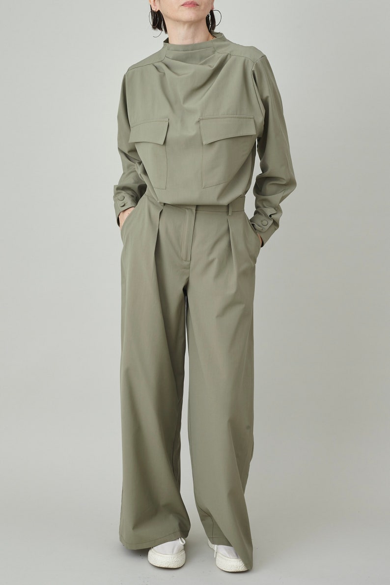 May include: A green, long-sleeved collared shirt with two large pockets on the front, paired with matching green wide-leg pants.