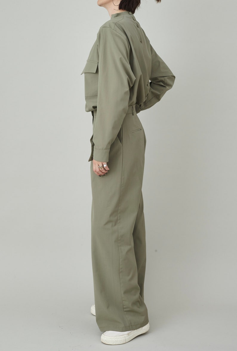 May include: A green collared shirt with long sleeves and a matching pair of wide-leg pants.