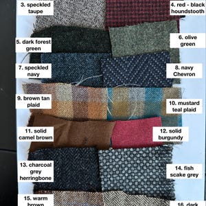 May include: A swatch card with 16 different fabric samples. The samples are arranged in two columns of eight. Each sample is labeled with a number and a description of the fabric. The fabrics include solid black, solid grey, speckled taupe, red-black houndstooth, dark forest green, olive green, speckled navy, navy chevron, brown tan plaid, mustard teal plaid, solid camel brown, solid burgundy, charcoal grey herringbone, fish scale grey, warm brown herringbone with blue plaid, and dark brown herringbone.