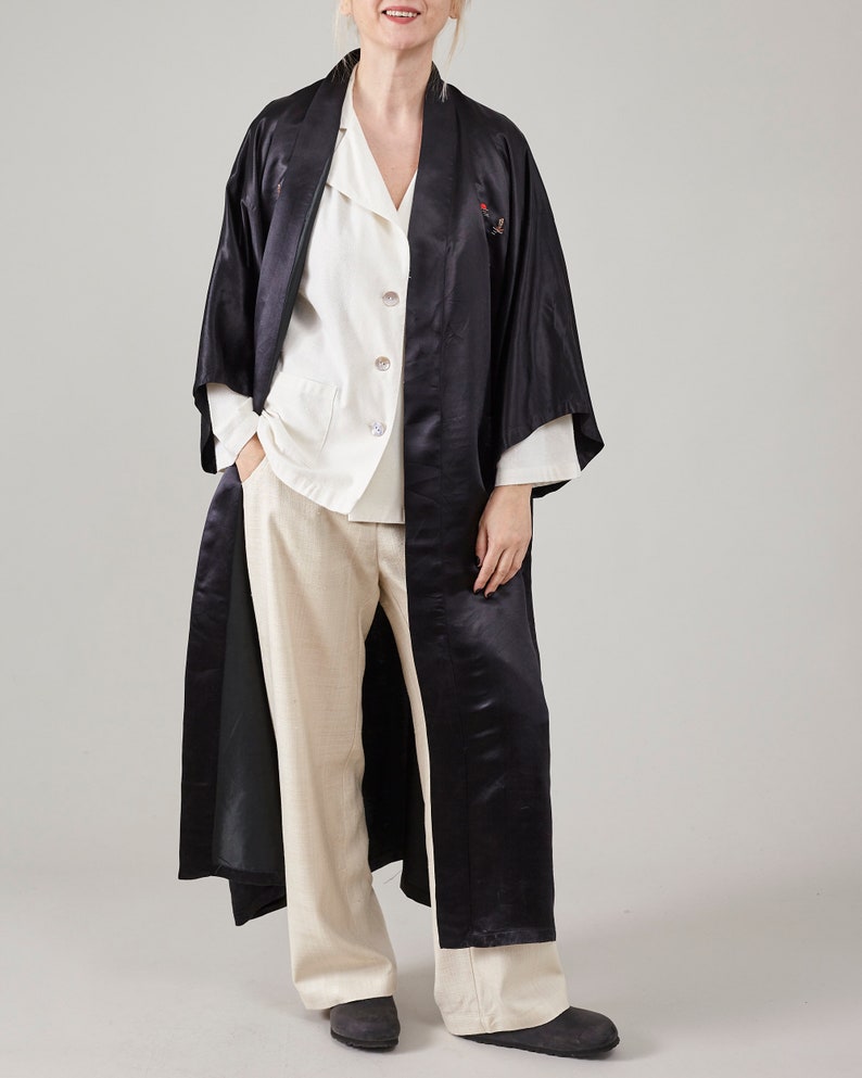 May include: A long black satin robe with a white button-up shirt underneath. The robe has a traditional Japanese style with a wide collar and long sleeves.