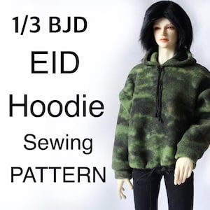 May include: A green and black camouflage-patterned hoodie on a doll. The hoodie has a drawstring and is paired with black pants. Text on the left reads "1/3 BJD EID Hoodie Sewing PATTERN."