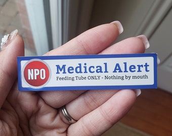May include: A blue and white medical alert sticker with the text "NPO Medical Alert Feeding Tube ONLY - Nothing by mouth".