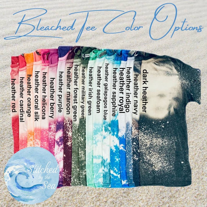 Op de afbeelding: Een verscheidenheid aan gebleekte t-shirt kleuren, waaronder donker grijs, marineblauw, indigo, koninklijkblauw, saffierblauw, Galapagos blauw, zeeschuim, Iers groen, legergroen, bosgroen, wijnrood, paars, bessen, heliconia, koraal zijde, oranje, kardinaalrood en rood. De tekst "Bleached Tee Color Options" staat bovenaan de afbeelding. De tekst "Stitched by the Sea" staat onderaan de afbeelding.