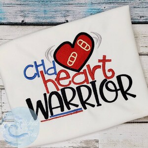 May include: White t-shirt with red, blue, and black embroidery. The embroidery says "Child heart warrior" with a red heart with band-aids on it.