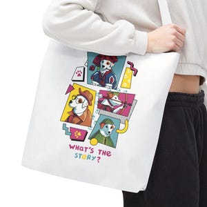 May include: White tote bag featuring a colorful graphic of cartoon dogs in various outfits. The phrase "WHAT'S THE STORY?" is printed in a playful font. The bag is carried over the shoulder.