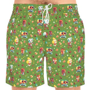 Puede incluir: Pantalones cortos de baño verdes con un patrón repetido de personajes de dibujos animados. Los pantalones cortos tienen un cordón blanco. Los personajes están en varias poses y colores. Hecho de material ligero.