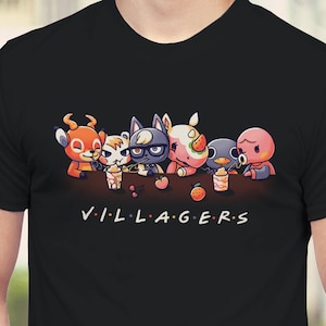 May include: Black t-shirt with a graphic of five animal characters from the Animal Crossing video game series. The characters are sitting at a table with drinks and fruit. The text "VILLAGERS" is printed below the graphic.