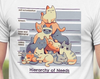 May include: White t-shirt with a graphic of a pyramid of cats representing Maslow's Hierarchy of Needs. The text "Hierarchy of Needs" is printed below the pyramid.