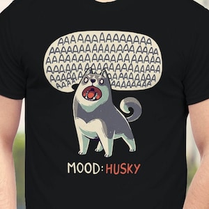 Puede incluir: Camiseta negra con un perro husky de dibujos animados aullando con una burbuja de diálogo sobre su cabeza llena de la letra "A" repetida muchas veces. El texto "MOOD: HUSKY" está debajo del perro.