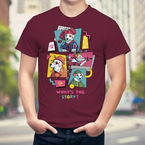 Op de afbeelding: Bordeauxrood T-shirt met een grafisch ontwerp van vier honden in verschillende kostuums, tegen kleurrijke geometrische vormen. De tekst "WHAT'S THE STORY?" staat eronder. Het shirt is gemaakt van zacht materiaal.
