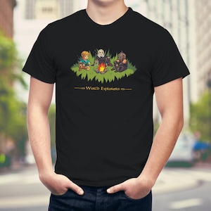 May include: Black t-shirt with a graphic of three video game characters around a campfire. The text "World Explorers" is printed below the graphic.