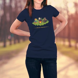 May include: A navy blue t-shirt with a graphic of three cartoon characters sitting around a campfire. The text "World Explorers" is printed below the graphic.