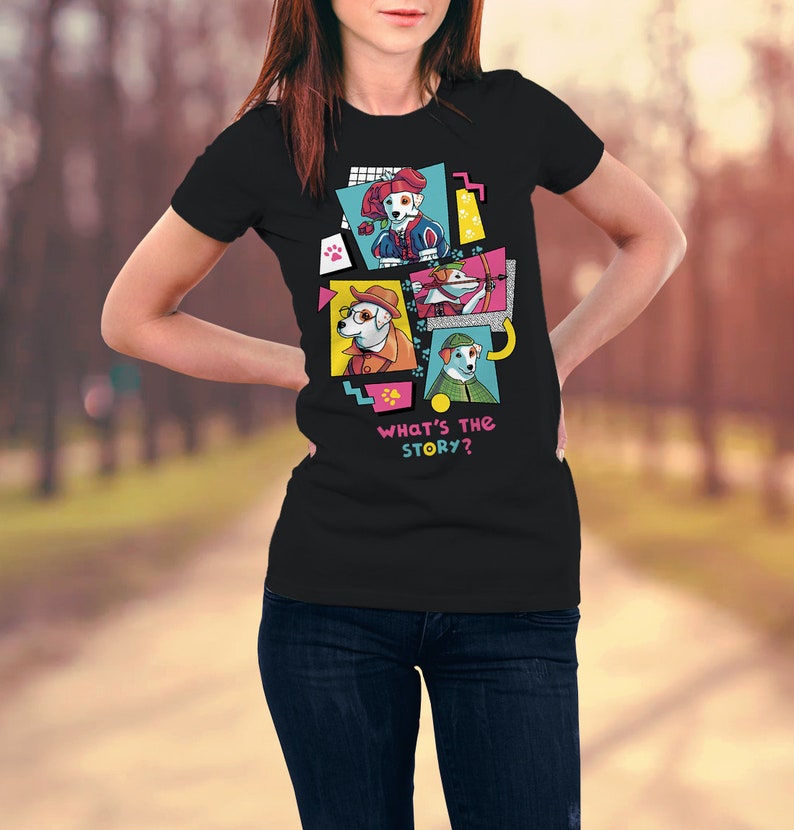 Op de afbeelding: Zwart t-shirt met een kleurrijke afbeelding van cartoonhonden in verschillende outfits. Het ontwerp bevat de tekst "WHAT'S THE STORY?" in roze en blauw. De honden zijn afgebeeld in een pop-art stijl, met felle kleuren en geometrische vormen.
