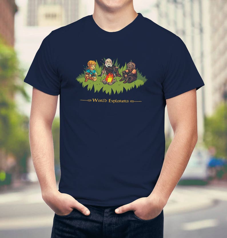 May include: A navy blue t-shirt with a graphic of three cartoon characters around a campfire. The text "World Explorers" is printed below the graphic.