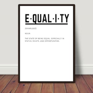 May include: A framed print with the word "EQUALITY" in bold black letters. Below the word is the phonetic pronunciation, the word "NOUN", and a definition of equality. The print is displayed on a wooden floor.