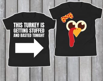 Może przedstawiać: Dwie czarne koszulki z motywami z okazji Święta Dziękczynienia. Jedna koszulka ma napis "THIS TURKEY IS GETTING STUFFED AND BASTED TONIGHT" z białą strzałką. Druga koszulka przedstawia twarz indyka z kreskówki z muszką.