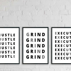 May include: Three black framed prints with white backgrounds. The prints feature the words "Hustle", "Grind", and "Execute" repeated in a stacked pattern. The words are in black and gray.