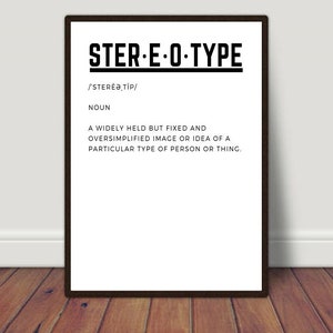 May include: A framed print featuring the word "STER-E-O-TYPE" in black, with its phonetic pronunciation and definition below. The print is displayed on a white wall above a wooden floor, creating a simple and modern aesthetic. The definition is in English.