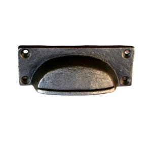 May include: A weathered, grey metal drawer pull with a curved handle. The rectangular base has four screw holes, one in each corner. The handle is a half-moon shape, providing a comfortable grip for opening drawers or cabinets.