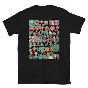 Op de afbeelding: Zwart T-shirt met een kleurrijk gepixeld ontwerp met verschillende retro videogame- en computersymbolen. Het ontwerp bevat een verscheidenheid aan kleuren, waaronder roze, blauw, groen en geel.