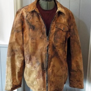 Puede incluir: Chaqueta marrón con cremallera completa, un pequeño bolsillo en el pecho y cuello. La chaqueta tiene un patrón moteado único de marrón oscuro y negro. Se ve una camisa granate debajo.