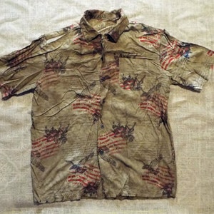 May include: A short-sleeved button-down shirt with a faded brown and red print of American flags and eagles.