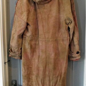 May include: A long, brown, hooded jacket with a tie at the bottom. The jacket has a distressed look and is made of a soft, textured fabric.