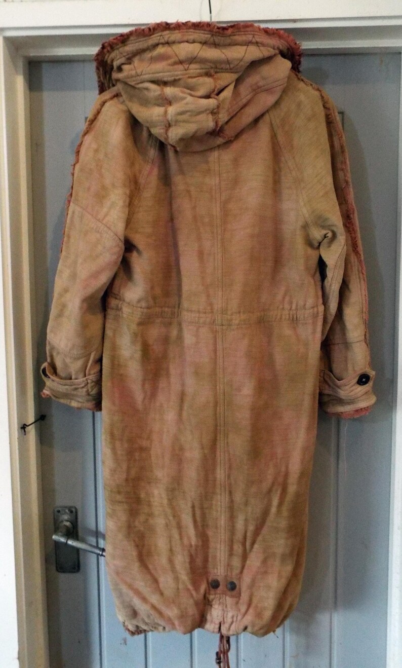 May include: A long, brown, hooded jacket with a tie at the bottom. The jacket has a distressed look and is made of a soft, textured fabric.