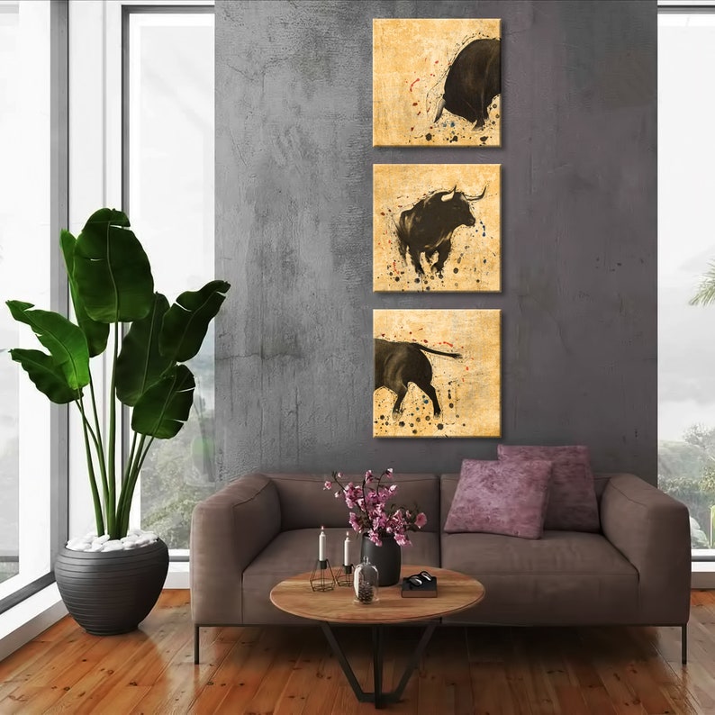 May include: Three abstract paintings of black bulls on a beige background with black splatters of paint. The bulls are in different poses, one is charging, one is running, and one is standing still.