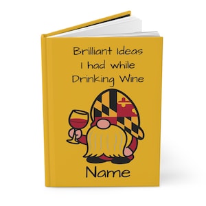 May include: A yellow journal with the text "Brilliant Ideas I had while Drinking Wine" and a gnome illustration holding a wine glass. The gnome's hat features a Maryland flag design, and the word "Name" is at the bottom.