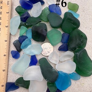 May include: A collection of sea glass in various shades of blue, green, and white, with a ruler showing inches. A US quarter is included for size reference. The text "#6" is visible.