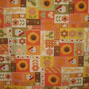 May include: A patchwork fabric with an autumnal theme. The fabric features a variety of autumn colours, including orange, yellow, brown, and green. The fabric is decorated with a variety of autumn-themed designs, including pumpkins, sunflowers, leaves, and birds.