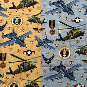 May include: A beige and blue fabric with a repeating pattern of military aircraft, helicopters, stars, and Air Force insignia. The fabric features a camouflage pattern and the text "United States Air Force".
