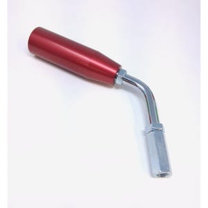 May include: A red metal handle with a curved, chrome-colored arm and a silver-colored, hexagonal base. The handle is cylindrical and tapers slightly towards the end. The chrome arm connects the handle to the base.