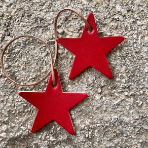 May include: Two red leather star ornaments with brown leather strings.