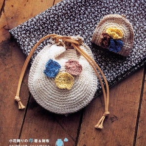 Puede incluir: Dos bolsas de ganchillo con adornos florales. La bolsa más grande es una bolsa de cordón con un cordón de color canela. La bolsa más pequeña es una cartera de monedas con cierre de presión. Ambas bolsas están decoradas con flores de ganchillo en azul, amarillo y rosa.