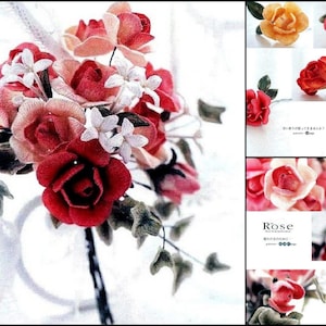 May include: A bouquet of fabric roses in shades of pink, red, and white. The roses are arranged in a cluster with green leaves and white fabric flowers.