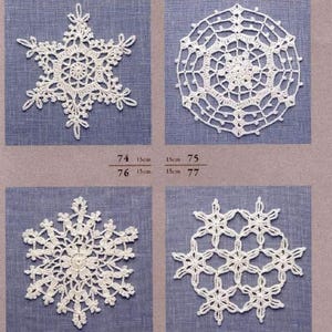 Op de afbeelding: Vier witte gehaakte sneeuwvlokontwerpen. De sneeuwvlokken hebben een diameter van 15 cm. De ontwerpen zijn genummerd 74, 75, 76 en 77.