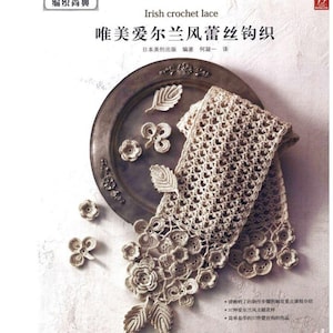 May include: A book titled "唯美爱尔兰风蕾丝钩织" (Beautiful Irish Lace Crochet) with a close-up image of a crocheted lace scarf on a silver tray. The scarf is made with a delicate, intricate pattern of flowers and leaves.