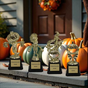 May include: Four gold-colored Halloween-themed trophies with black bases. The trophies feature a scarecrow, zombie, witch on a broom, and a pumpkin design. Each trophy has a gold plate that says "PERSONALIZE HERE". Pumpkins are in the background.