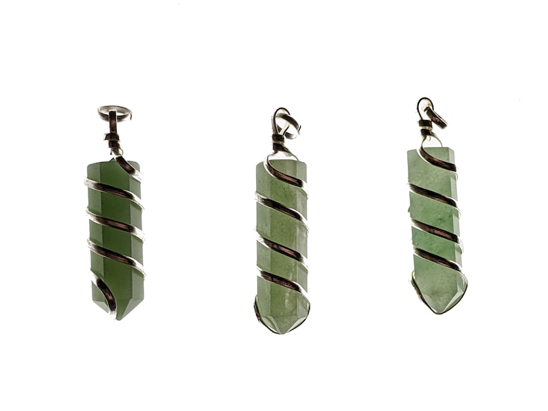 May include: Three green gemstone pendants with silver wire wrapping. Each pendant is a long, hexagonal shape with a pointed end. The silver wire spirals around the stone, and a silver loop is at the top for hanging.